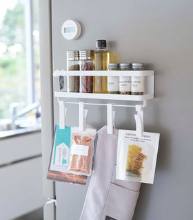 White Magnetic Organizer with Easy-Grip Rotating Clips holding kitchen items above sink by Yamazaki Home. view 2