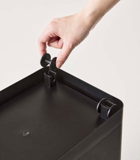 Bottom view of person attaching product part to black Airtight Food Storage Container on white background by Yamazaki Home. view 15