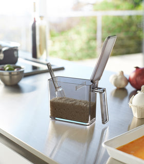 Side view of white Udnershelf Organizer holding paper towel on kitchen shelf by Yamazaki Home. view 7