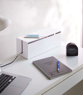 White Cable Management Box holding charging cords on office desk by Yamazaki Home. view 2