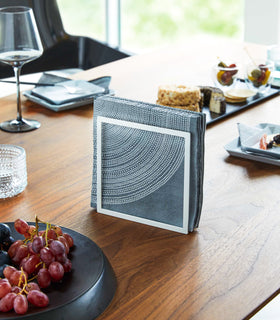 Front view of white Napkin Holder holding napkins on dining table by Yamazaki Home. view 2