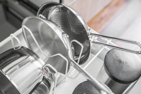 Black Slim Dish Rack holding silverware and dishware on kitchen counter by Yamazaki Home. view 5