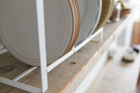 Close up bottom view of Wood-Accented Dish Storage Rack holding plates on shelf by Yamazaki Home. view 6