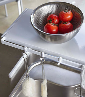 Close up of white Expandable Countertop Organizer displaying bowl\ and cleaning utensils by Yamazaki Home. view 8