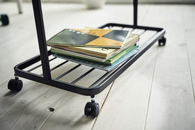 Bottom view of black Rolling Coat Rack holding books by Yamazaki Home. view 12