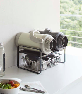 Black Expandable Countertop Organizer holding bottles on kitchen countertop by Yamazaki Home. view 10