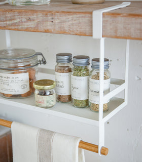 White Undershelf Organizer holding spices and dish towel by Yamazaki Home. view 6