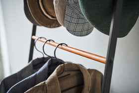 Close up of clothes hung on black Yamazaki Home Coat Rack with Hat Storage view 15