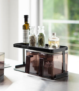 Black Pantry Organizer holding spices on upper shelf in kitchen by Yamazaki Home. view 20