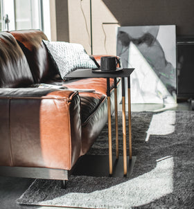 Side view of black C Side Table holding coffee cup in living room by Yamazaki Home. view 8