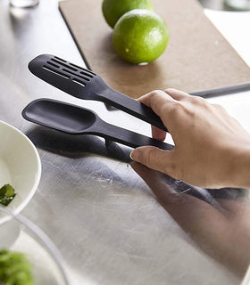 Black Slotted Tongs on kitchen counter by Yamazaki Home. view 24