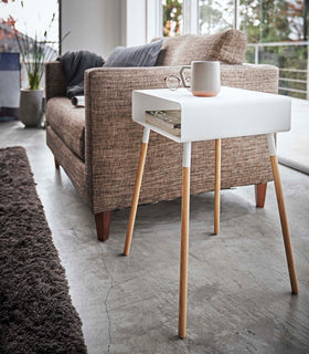 White Storage Table holding books and coffee in living room by Yamazaki Home. view 8