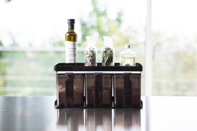 Front view of black Pantry Organizer holding baking ingredients and upper shelf holding spices and oil by Yamazaki Home. view 22