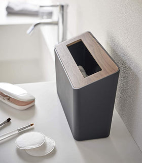 Side view of black Countertop Waste Bin on bathroom sink countertop by Yamazaki Home. view 10