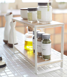 Side view of white Countertop Shelf on kitchen counter displaying spices and oil by Yamazaki Home. view 4