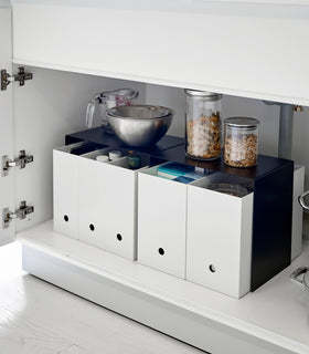 Yamazaki Black Under-Cabinet Storage Shelves holding bowls and baskets on top and four storage boxes underneath. view 9