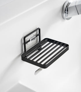 Yamazaki Home's black Traceless Adhesive Soap Tray mounted on a bathroom wall. view 12