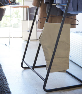 Close up bottom view of black 2-level Coat Rack displaying clothes by Yamazaki Home. view 11