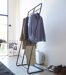 Black 2-level Coat Rack holding clothes by Yamazaki Home. view 9