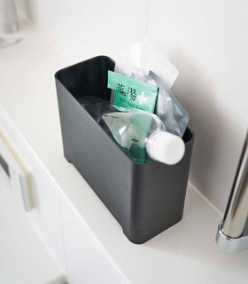 Top-down view of black Yamazaki Self-Draining Bathroom Organizer filled with bath supplies view 13