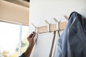 Ash Wall-Mounted Coat Hanger with removable hook displaying purse and jacket by Yamazaki Home. view 5