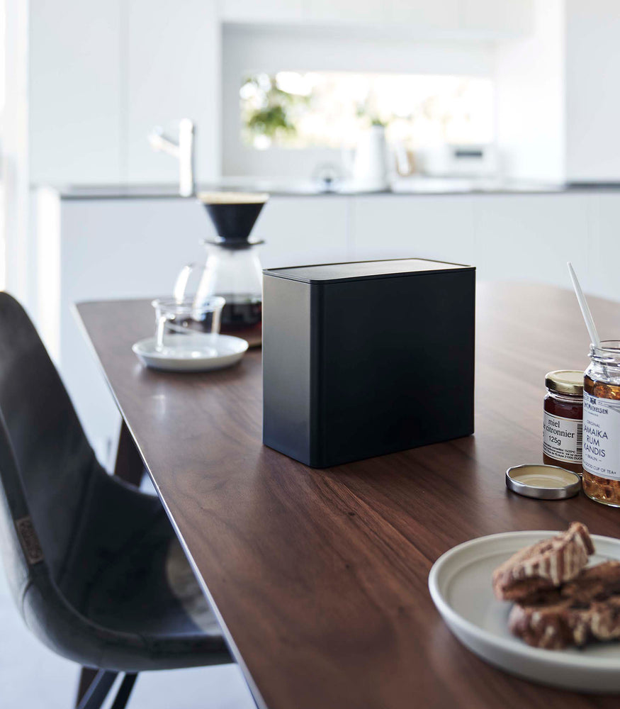 View 16 - Black Yamazaki Home kitchen storage box with a closed lid on dining table