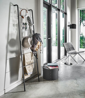 Side view of black Leaning Ladder with Grid Panel holding accessories in living room by Yamazaki Home. view 8