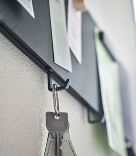 Closeup of Yamazaki black Magnetic Wall Panel with a key hanging from a hook view 11