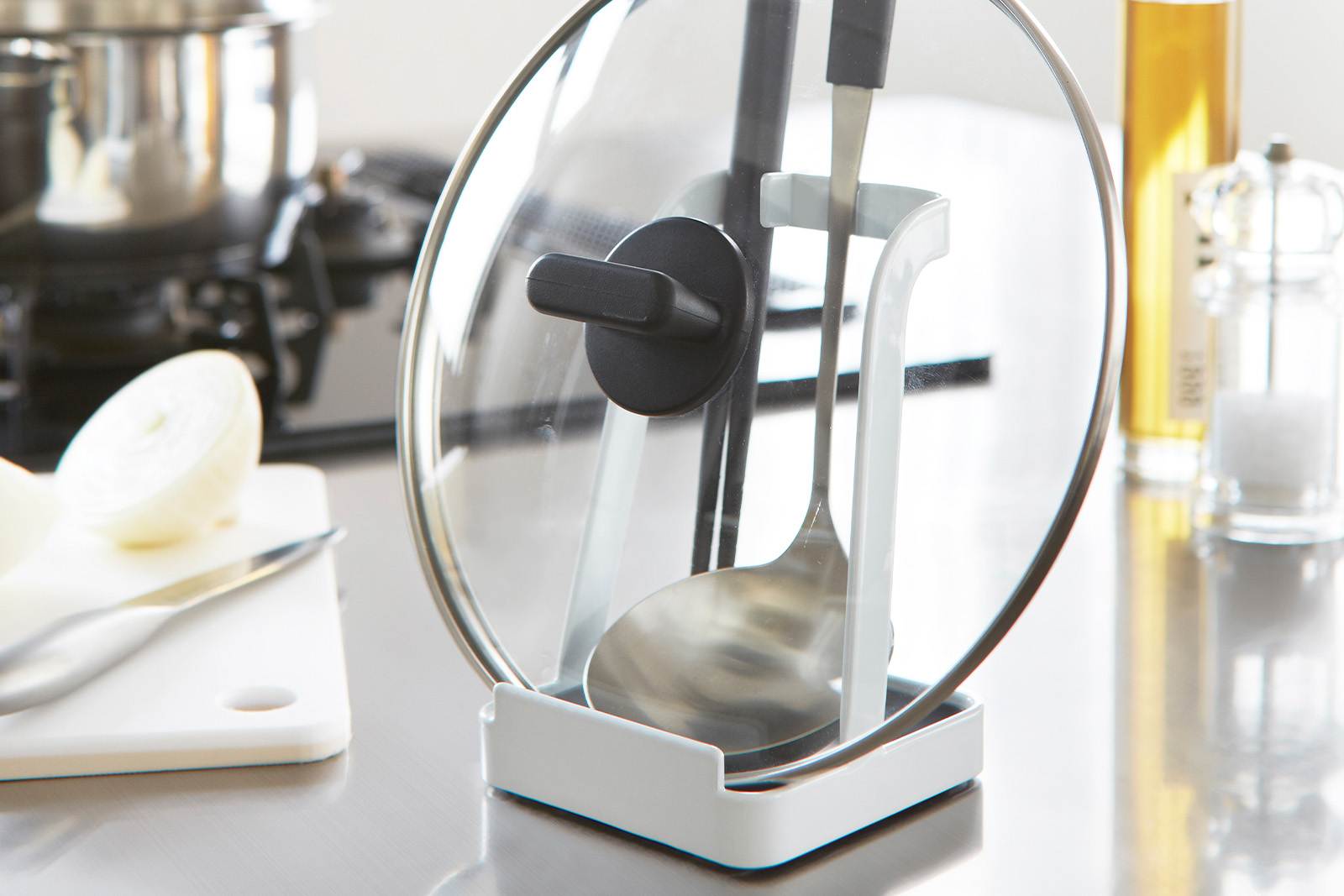 Yamazaki Home Lid & Ladle Stand holding a lid and a ladle on a kitchen counter. 