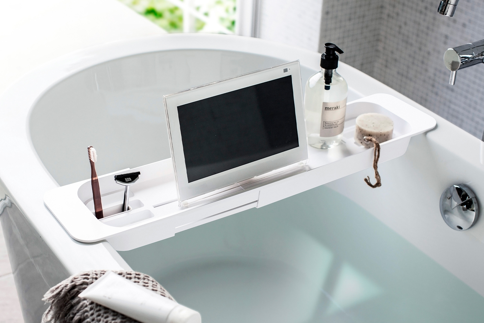 Yamazaki Home Expandable Bathtub Caddy holding a tablet on the bathtub. 