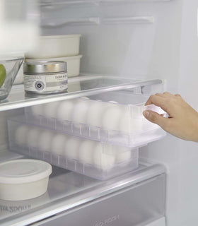 Yamazaki Egg Container for Refridgerator inside a fridge with eggs inside being pulled out view 13