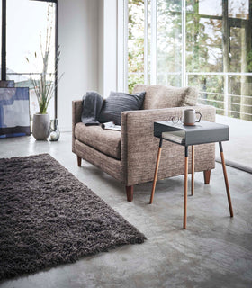 Black Storage Table holding books, cup, and glasses in living room by Yamazaki Home. view 18