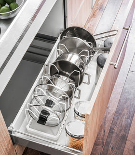 Aerial view of white Adjustable Pot Lid Organizer in kitchen drawer by Yamazaki home. view 3