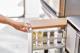 Partial front view of white Rolling Storage Cart holding spices in kitchen by Yamazaki Home. view 3