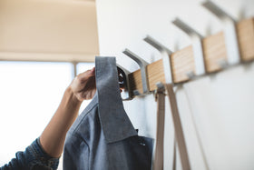 Close upview of ash Wall-Mounted Coat Hanger holding jacket and purse by Yamazaki Home. view 4