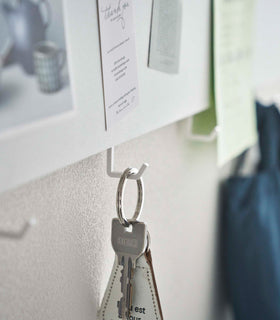 Closeup of Yamazaki white Magnetic Wall Panel with a key hanging from a hook view 4