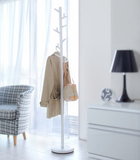 Front view of white Coat Rack holding jacket and purse by Yamazaki Home. view 3