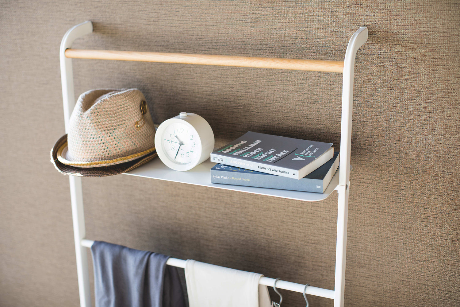 View 13 - Close up top view of white Leaning Ladder Rack with Shelf displaying hat, clock, and books by Yamazaki Home.