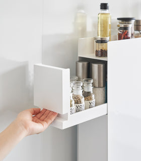 Close up of top tier of white Yamazaki Home Two-Tier Sliding Drawer Seasoning Rack being opened view 5