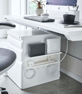 White Wall-Mount Cable and Router Storage Rack attached to side of cabinet holding router and power cord in office by Yamazaki Home. view 2