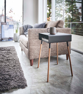 Side view of black Storage Table holding coffee cup and books in living room by Yamazaki Home. view 14