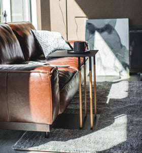 Side view of black C Side Table displaying coffee cup in living room by Yamazaki Home. view 10