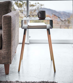 Front view of black Storage Table holding book and coffee cup in living room by Yamazaki Home. view 17