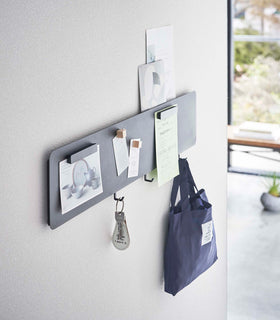 Side view of a Yamazaki black Magnetic Wall Panel with keys and a bag hanging from hooks view 10