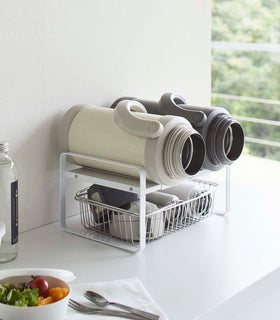 White Expandable Countertop Organizer holding bottles on kitchen countertop by Yamazaki Home. view 4