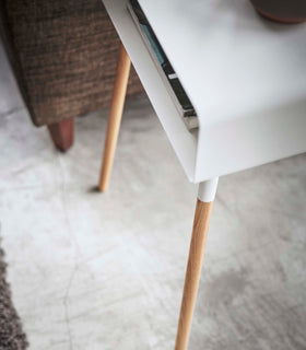 Close up corner aerial view of white Storage table holding books in living room by Yamazaki Home. view 12