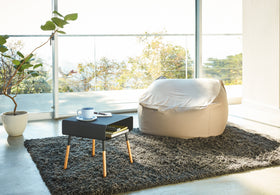 Black Short Storage Table containing books in living room by Yamazaki Home. view 24