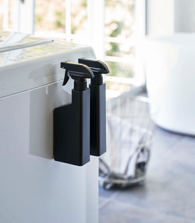 Two black Magnetic Spray Bottles mounted to washing machine by Yamazaki Home. view 9