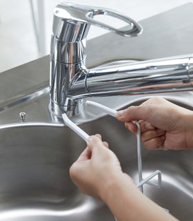 White Faucet-Hanging Sponge Holder attatching to kitchen sink by Yamazaki Home. view 11