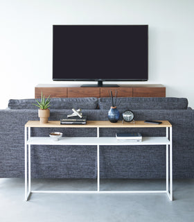 Frontal image of white Yamazaki Home Long Console Table - Shelf with books and decorations on it view 20